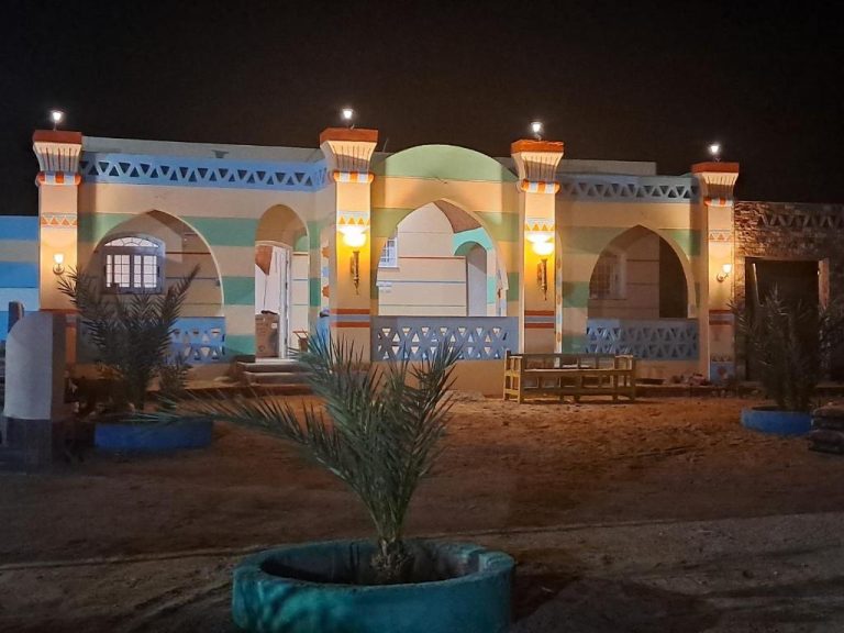 Fachada exterior iluminada del Aton Palace Luxor con arcos y decoración egipcia tradicional de noche