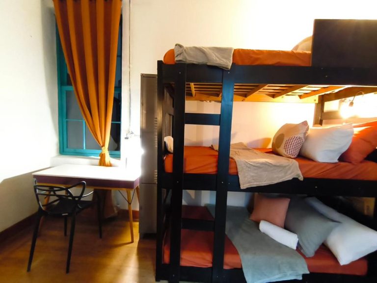 Habitación con literas y sábanas naranjas en Hobi Hotel Boutique Bela Vista, cerca de Av Paulista