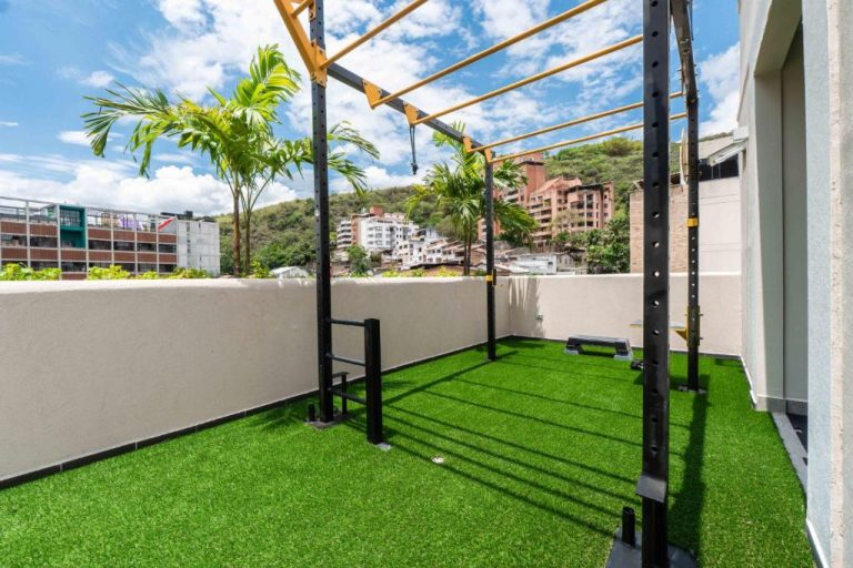 Terraza con gimnasio al aire libre y césped artificial en Veca Flats Centenario Cali