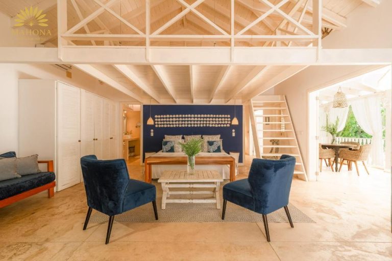 Suite loft con sillones azules, cama y altillo en Mahona Boutique Hotel