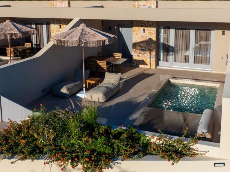 Piscina privada con tumbonas y sombrilla en la terraza exterior de Illusion Suites