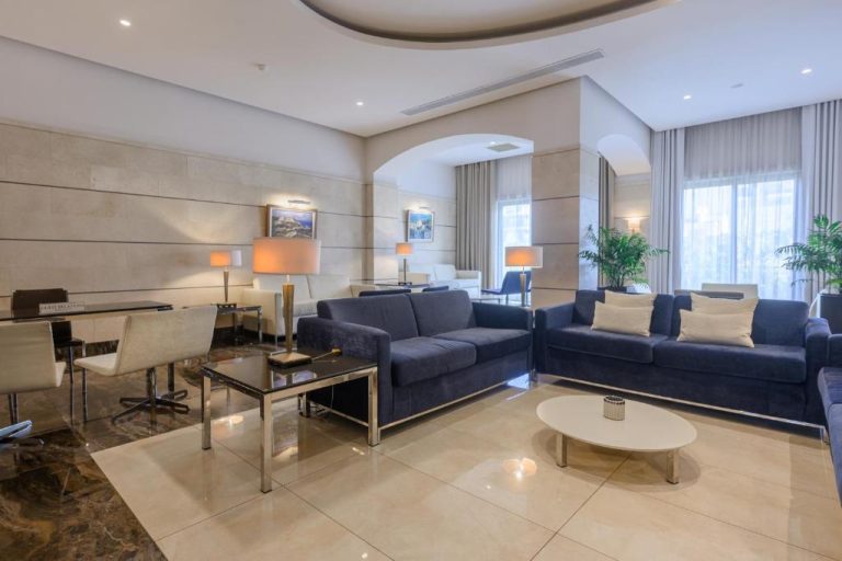 Elegante salón lobby con sofás azules y mesas de cristal en el Maritim Antonine Hotel & Spa
