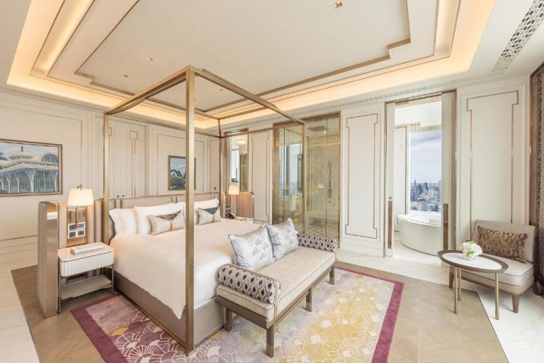 Suite de lujo con cama de dosel dorada y bañera panorámica en Eastin Grand Hotel Phayathai Bangkok