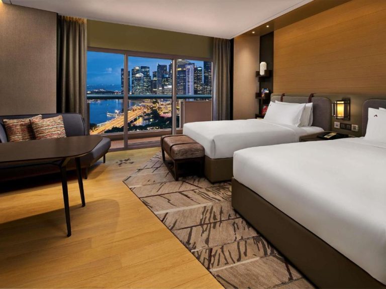 Habitación doble con vistas al skyline nocturno de Singapur en el Swissotel The Stamford Singapore