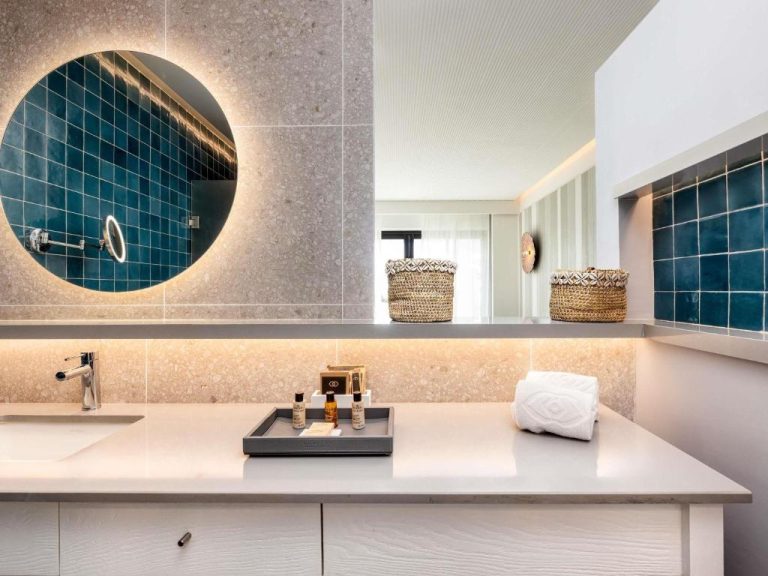 Baño de lujo con espejo retroiluminado y azulejos azules en Sofitel Agadir Thalassa Sea & Spa