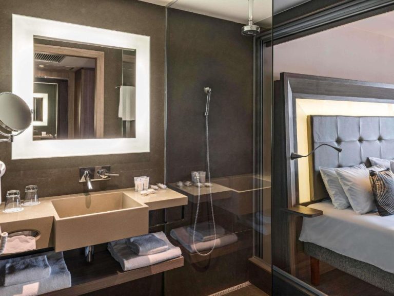 Baño moderno con ducha y lavabo de diseño en el Novotel RJ Praia de Botafogo