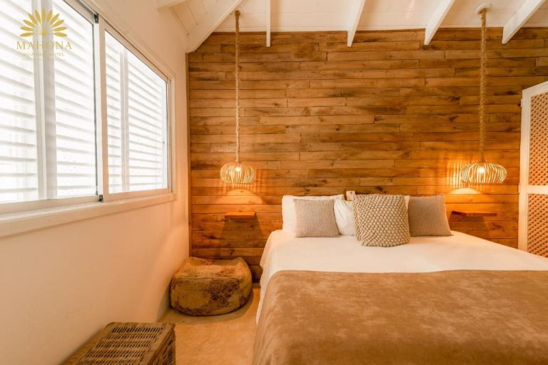 Habitación doble con pared de madera y lámparas colgantes en Mahona Boutique Hotel