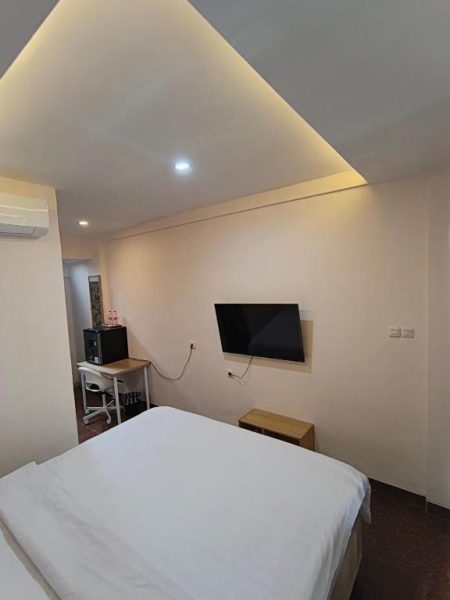Habitación doble con cama matrimonial y televisión en pared del hotel Casa Siligita Nusa Dua