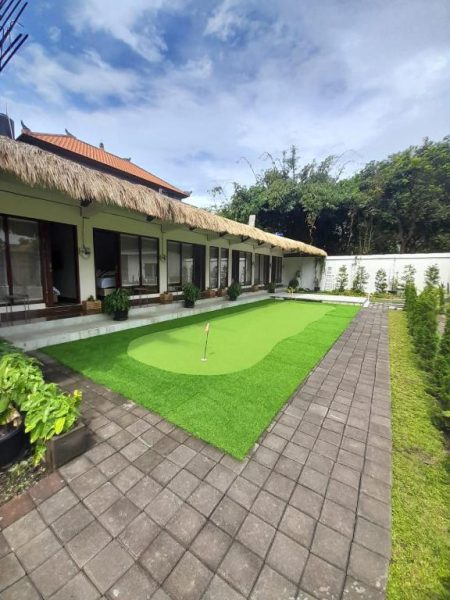 Campo de putting green privado rodeado de jardines tropicales en Casa Siligita Nusa Dua Bali