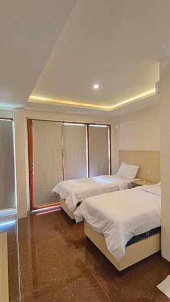 Habitación twin con dos camas individuales y techo decorativo en Casa Siligita Nusa Dua