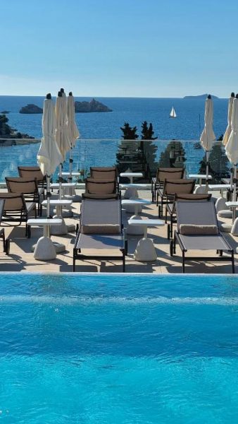 Piscina infinity con tumbonas y vistas al mar Adriático en el Hotel Sumratin