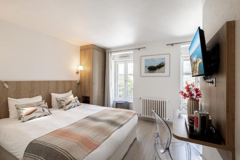 Habitación doble con cama grande y televisión del Hotel Restaurant Lesage, decoración moderna en tonos neutros