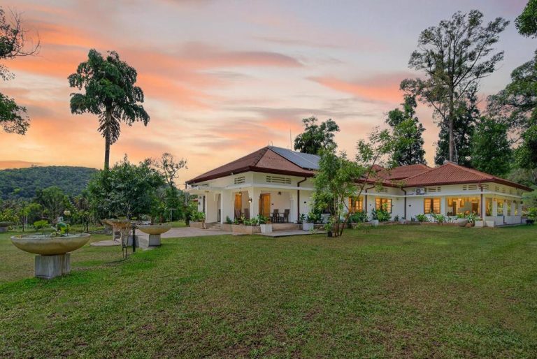 Villa exterior con jardín tropical al atardecer en The Tusker's Hideout rodeada de naturaleza