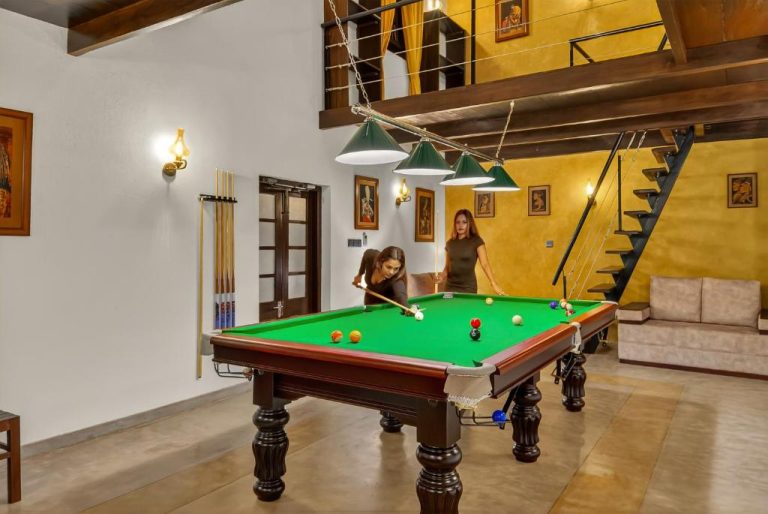 Sala de billar interior con mesa profesional y dos jugadoras en The Tusker's Hideout