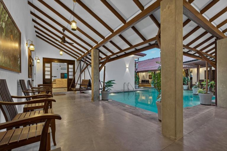 Terraza cubierta con piscina interior y mobiliario de madera en The Tusker's Hideout