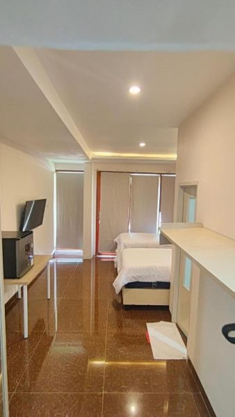 Habitación twin moderna con dos camas y televisión en Casa Siligita Nusa Dua, Bali