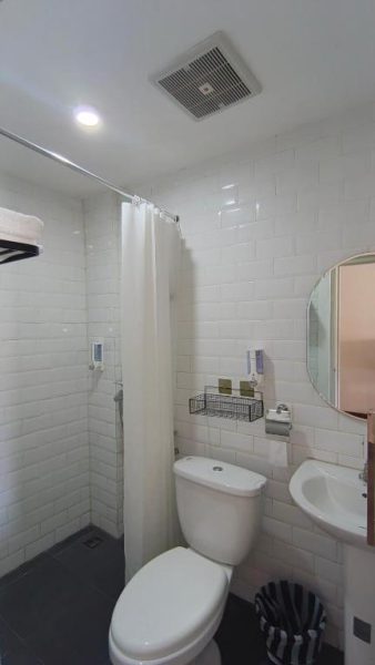 Baño privado con ducha, inodoro y lavabo en Casa Siligita Nusa Dua, decorado con azulejos blancos