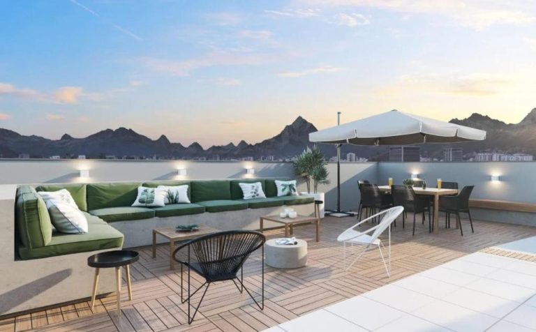 Terraza exterior con sofás verdes y zona de comedor con vistas a la montaña en Hospedagem para Grupos