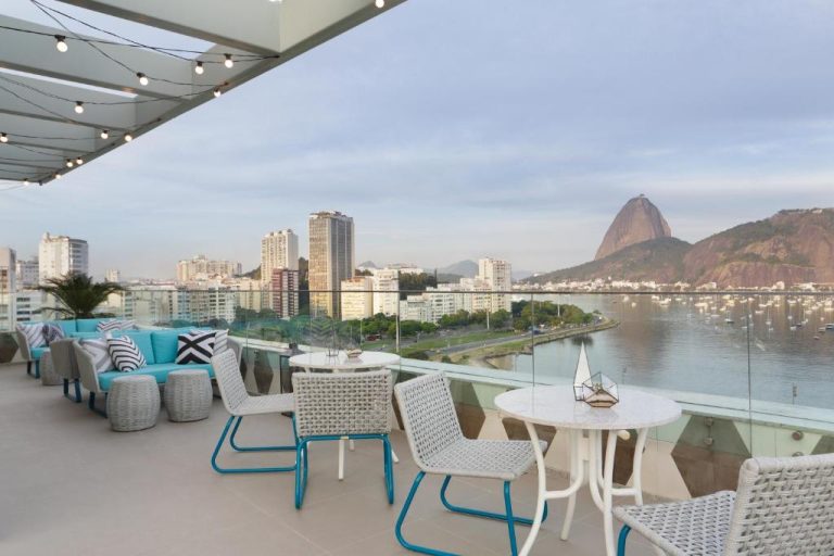 Terraza con mesas y sillones del Yoo2 Rio de Janeiro con vistas al Pan de Azúcar y la bahía