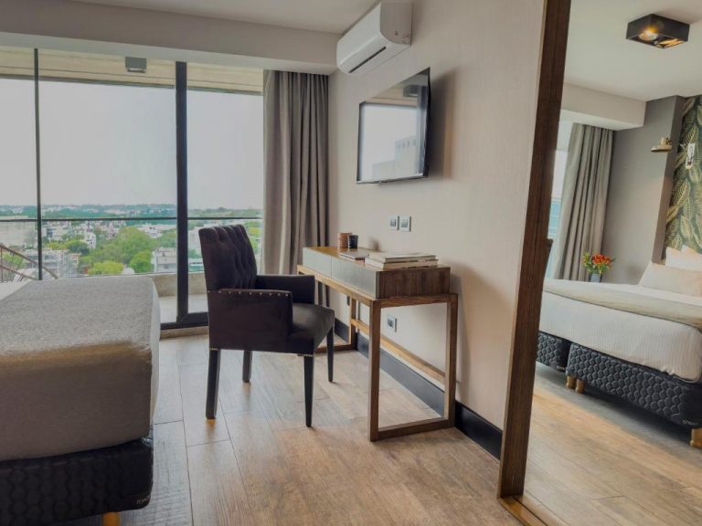 Habitación con escritorio, TV y amplia ventana con vista panorámica en Casa Joseph Libertador