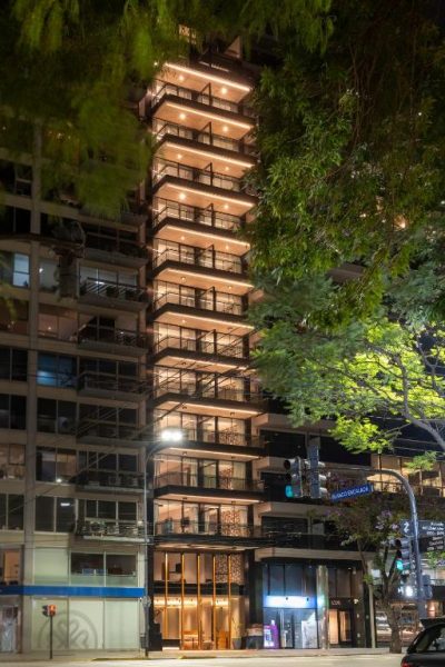 Fachada nocturna iluminada del hotel Casa Joseph Libertador con balcones y vista urbana