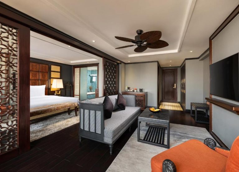 Suite con salón y dormitorio de estilo asiático en el Hanoi Solis Hotel con ventilador de techo