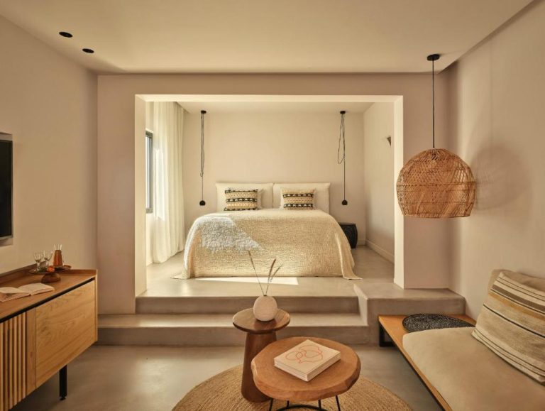 Suite con dormitorio elevado y zona de estar en Minos Beach Art Hotel, diseño mediterráneo minimalista