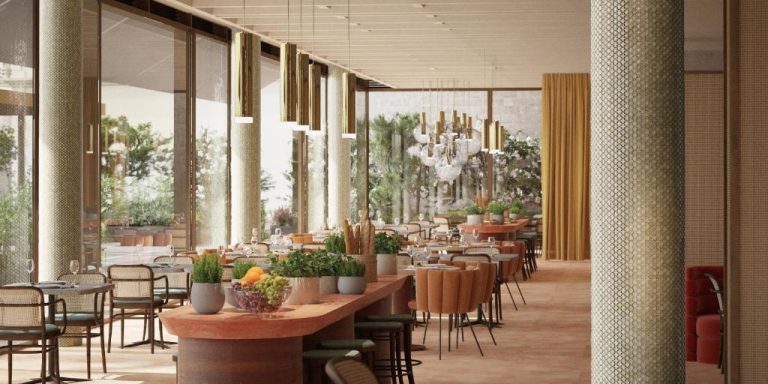 Restaurante interior del Villa Argentina con mesas decoradas, plantas naturales y grandes ventanales con luz natural