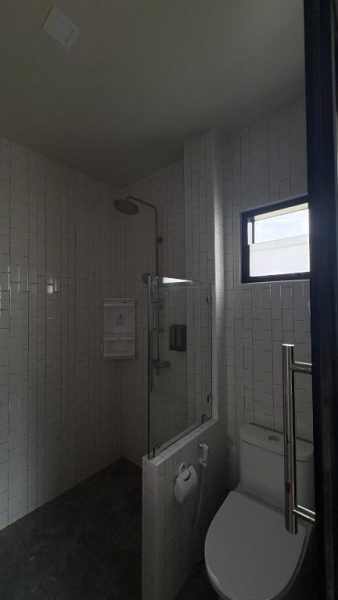 Baño moderno con ducha de lluvia y aseo en habitación del PS Lanta Resort en Tailandia