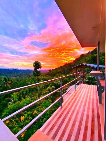 Terraza de madera con vistas panorámicas al atardecer en SZ Samui Glamping rodeada de naturaleza