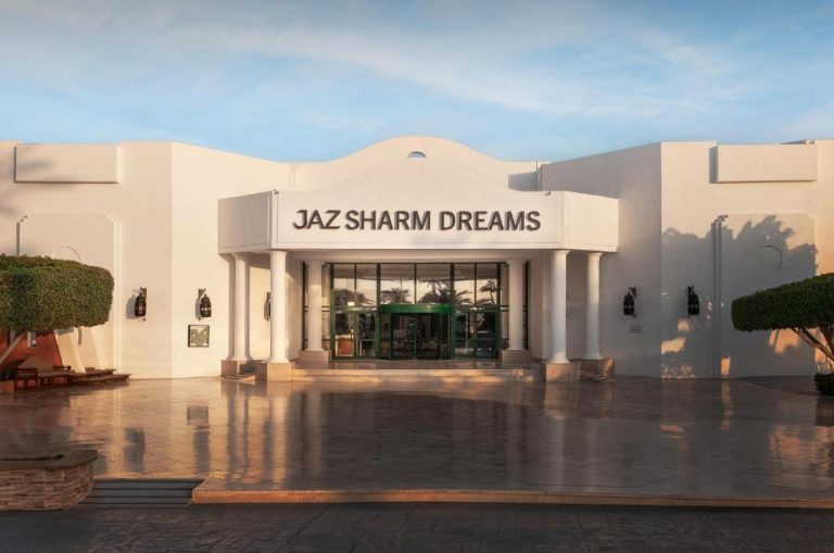 Entrada principal del hotel Jaz Sharm Dreams con fachada blanca y puerta giratoria en Sharm el Sheikh