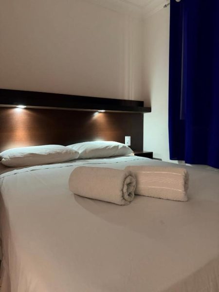Habitación doble con cama matrimonial y toallas enrolladas en Hotel Sol Brasil