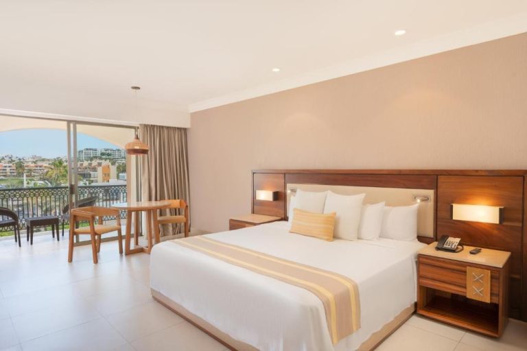 Habitación king size con balcón y vista exterior en Royal Solaris Los Cabos All Inclusive