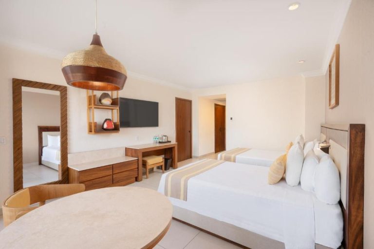 Habitación doble twin con dos camas, TV y escritorio en Royal Solaris Los Cabos All Inclusive