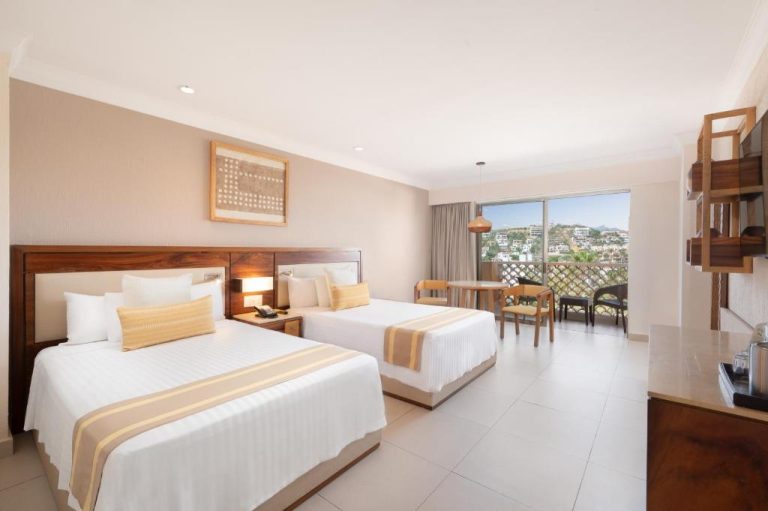 Habitación doble con dos camas y balcón con vistas al mar en Royal Solaris Los Cabos All Inclusive