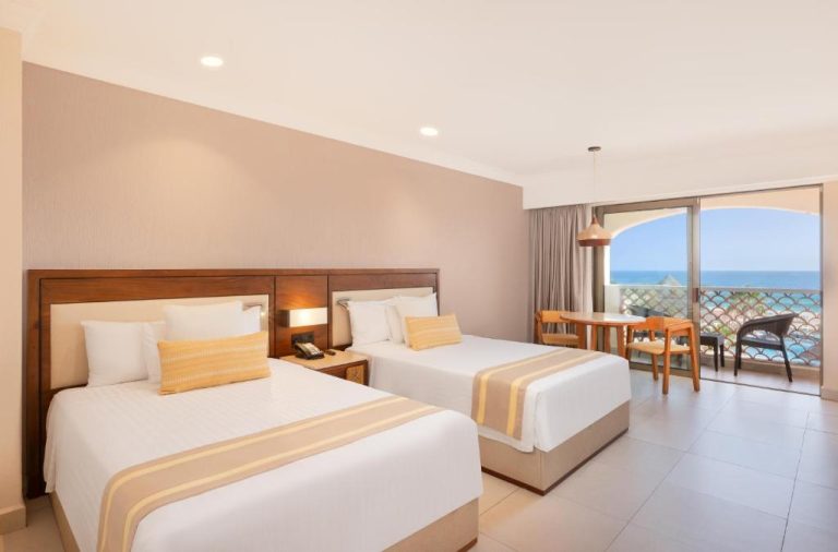Habitación doble con dos camas y balcón con vista al mar en Royal Solaris Los Cabos All Inclusive