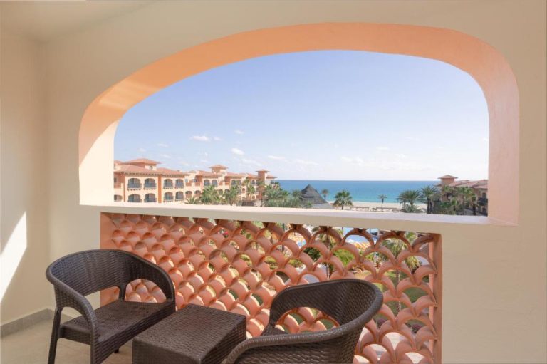 Balcón con sillas de ratán y vista al mar en Royal Solaris Los Cabos All Inclusive