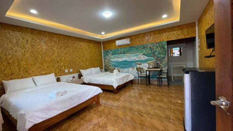 Habitación doble con dos camas y mural de cascada tropical en Baan Gamnan Resort Krabi