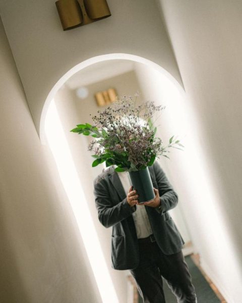 Recepcionista sosteniendo un elegante arreglo floral en el lobby del hotel Fausto by Andean