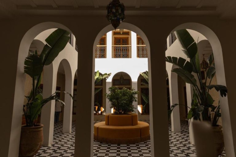 Patio interior con arcos blancos y vegetación tropical en The Mellah Hotel Marrakech