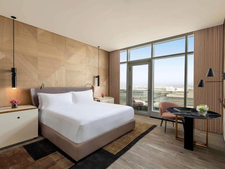 Habitación de lujo con cama king y vistas al circuito de carreras en Rixos Gulf Hotel Doha