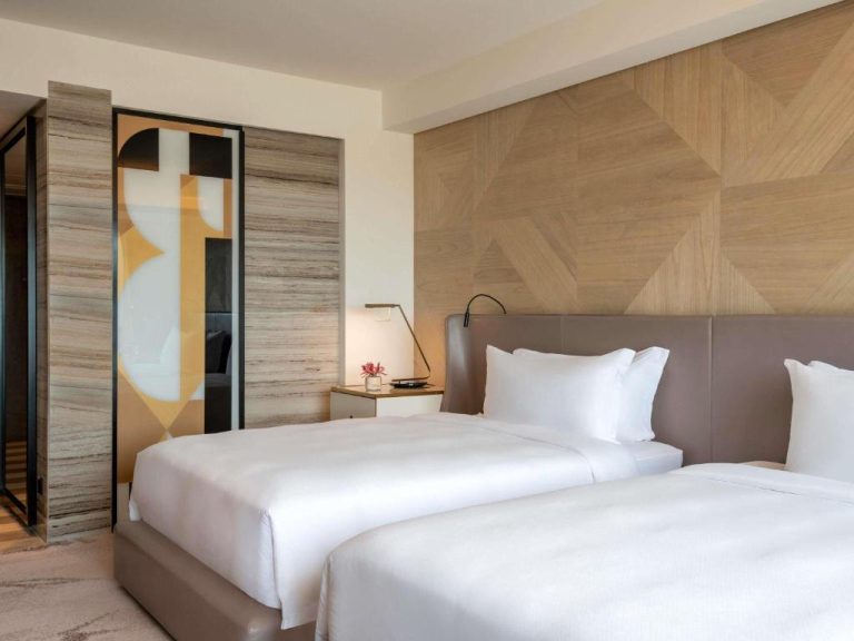 Habitación doble de lujo con camas king y cabecero de madera en Rixos Gulf Hotel Doha
