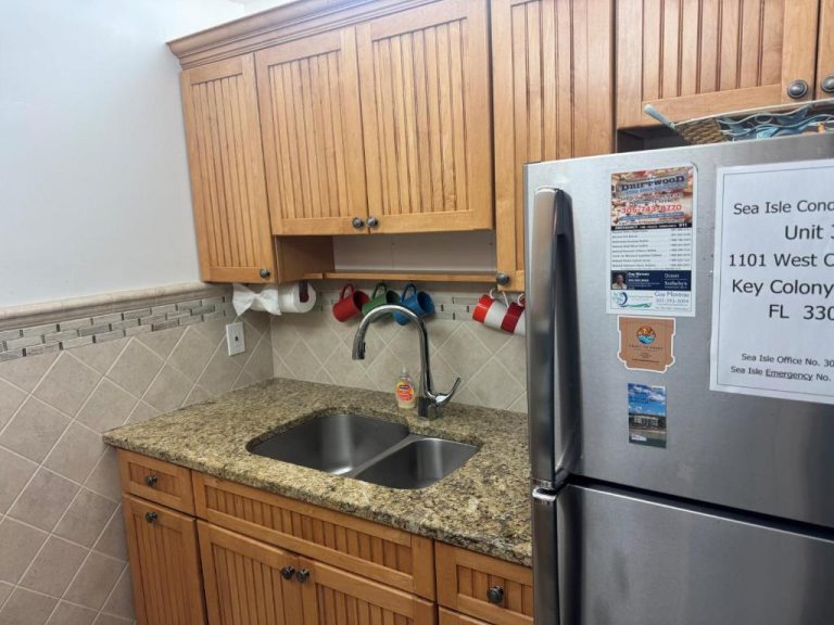 Cocina equipada con fregadero doble y nevera en apartamento de Key Colony Beach, Florida