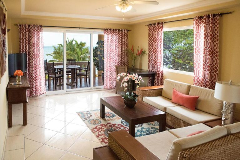 Amplia sala de estar con sofás y vistas al mar en Aruba Surfside Marina con terraza exterior