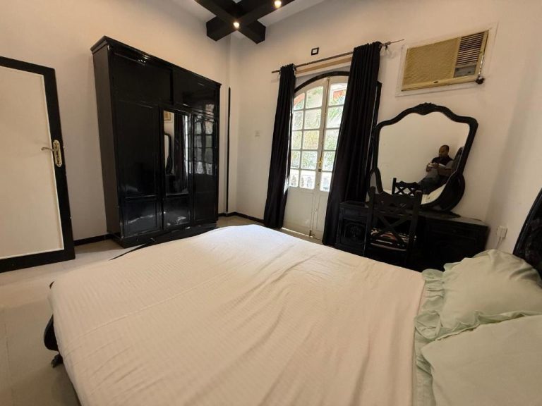 Habitación doble clásica con cama matrimonial y mobiliario negro en Ramla Palace House