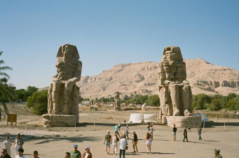 Colosos de Memnón en Luxor cerca del Ramla Palace House con turistas visitando las estatuas faraónicas