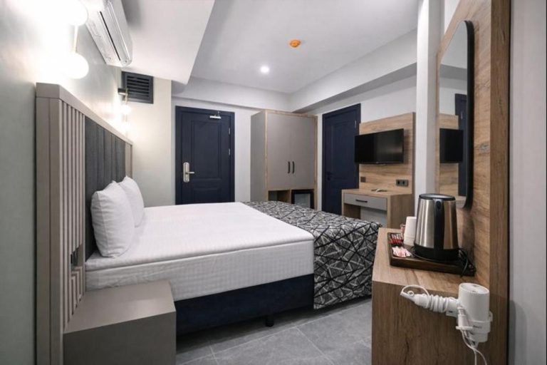 Habitación doble moderna con cama matrimonial y escritorio en Nas Corner Hotel