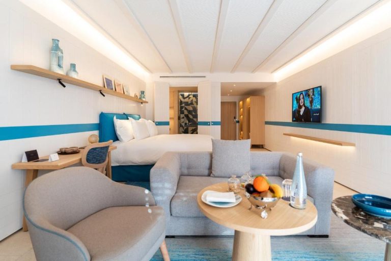 Junior Suite moderna con sofá, cama y decoración en azul turquesa en The View Agadir