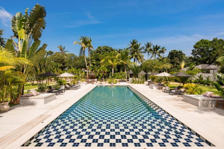 Piscina rectangular con mosaicos azules y jardín tropical en Moorea Boutique Resort Samui