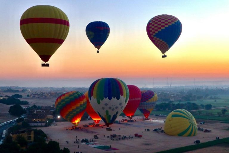 Vuelo de globos aerostáticos al amanecer sobre el desierto cerca del Bab Al Shams Palace en Dubái